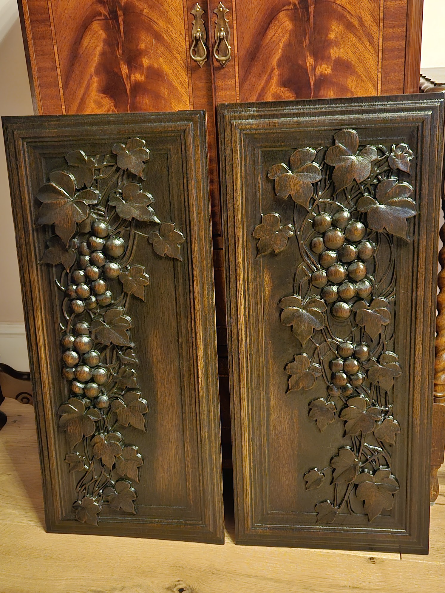 A matching pair of grape vines carved from solid oak. Stained with a dark oil finish and polished to a smooth sheen.