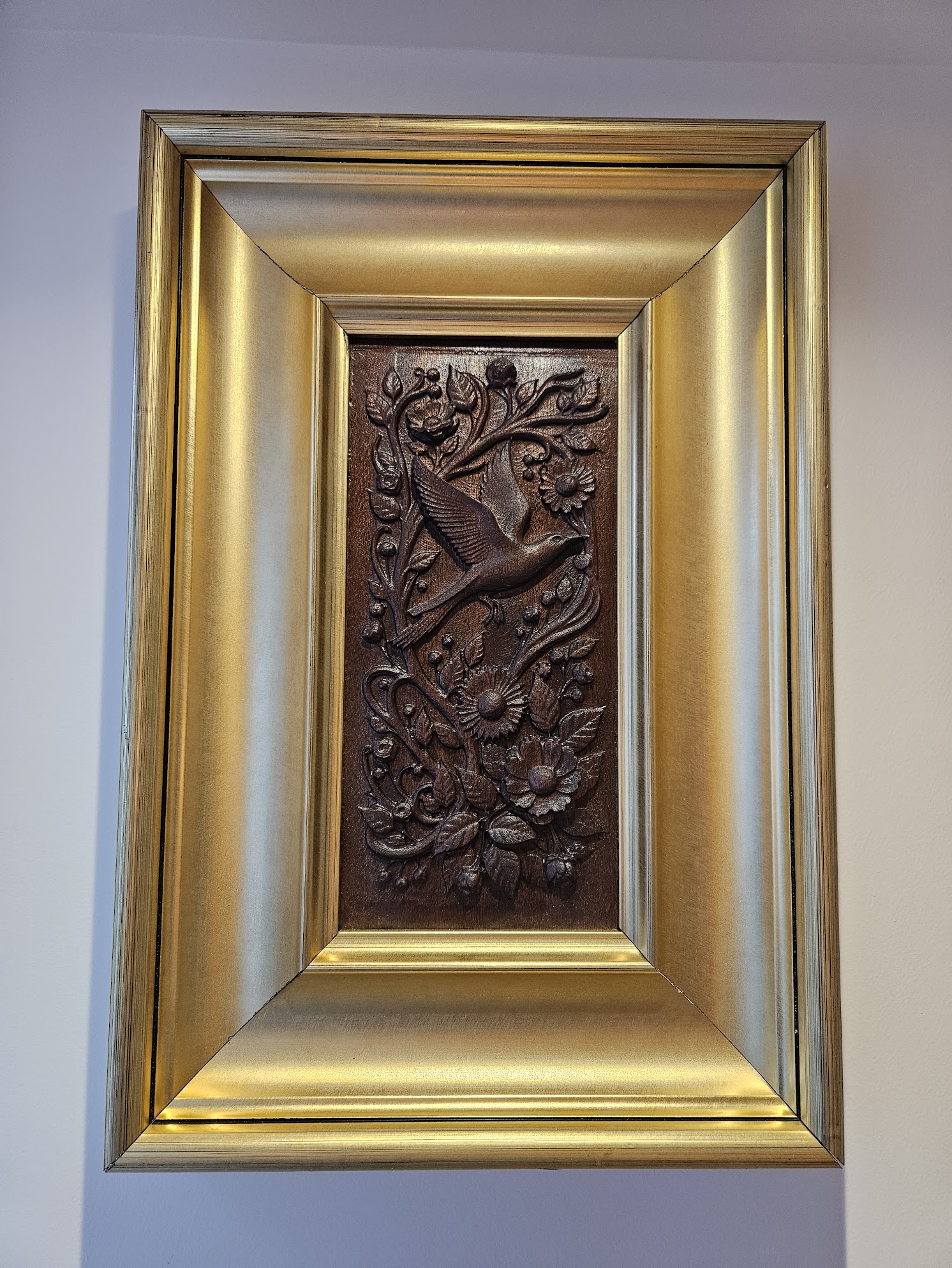 A bird spreading its wings. Carved on a single block of solid sapele. Accentuated with a bold golden frame.