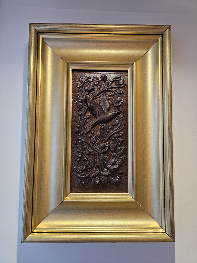 A bird spreading its wings. Carved on a single block of solid sapele. Accentuated with a bold golden frame.